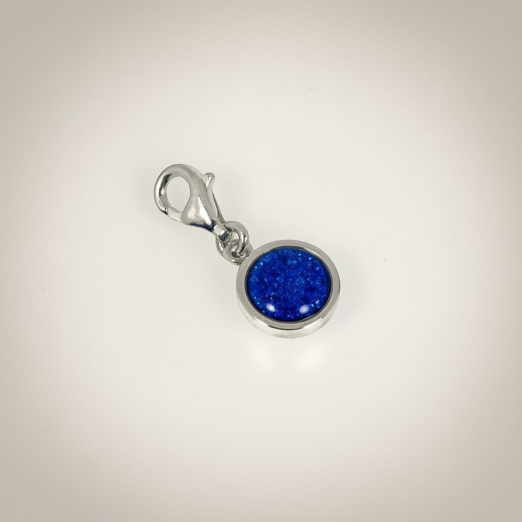 Ashes In Jewellery silver-tone round charm with blue glitter cremation ash and lobster clasp.