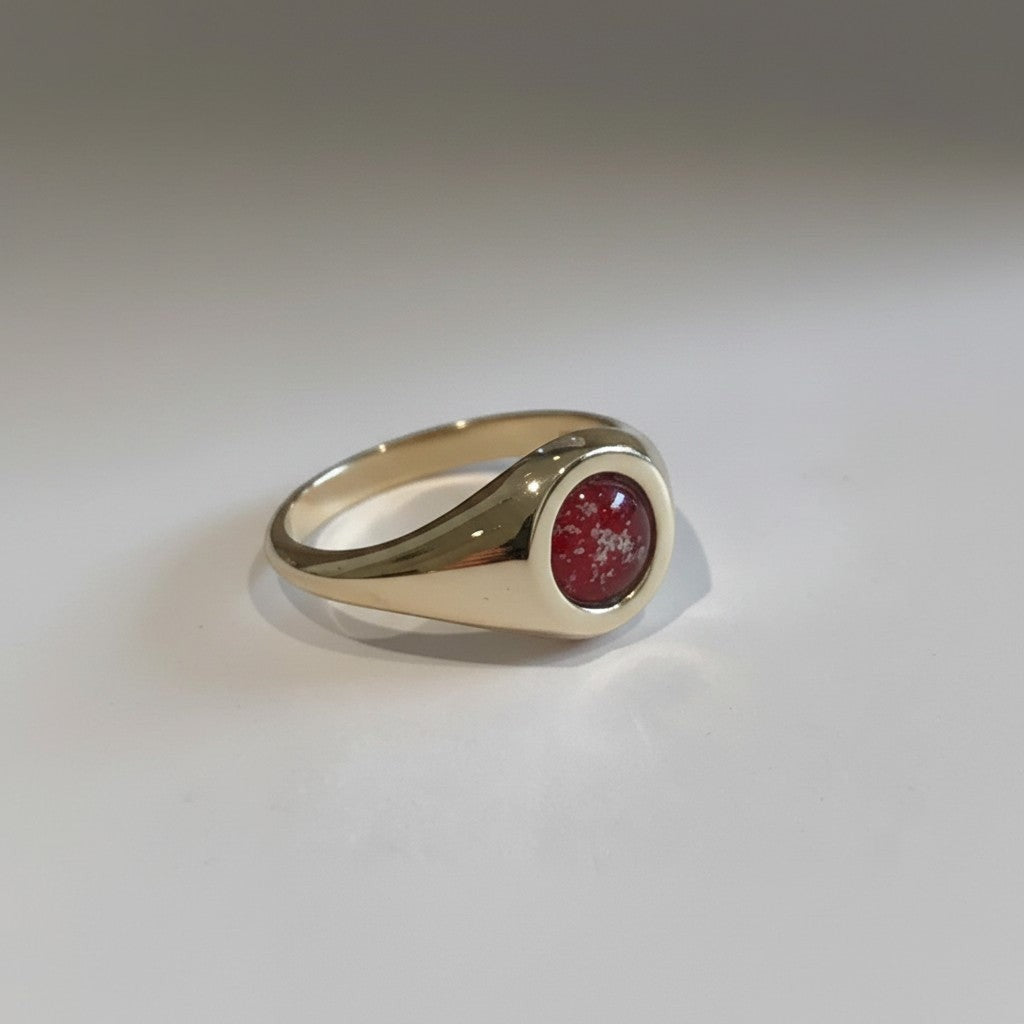 Ashes In Jewellery 14k yellow gold signet ring with a round cabochon stone containing red and white cremation ash.