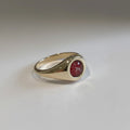Ashes In Jewellery 14k yellow gold signet ring with a round cabochon stone containing red and white cremation ash.