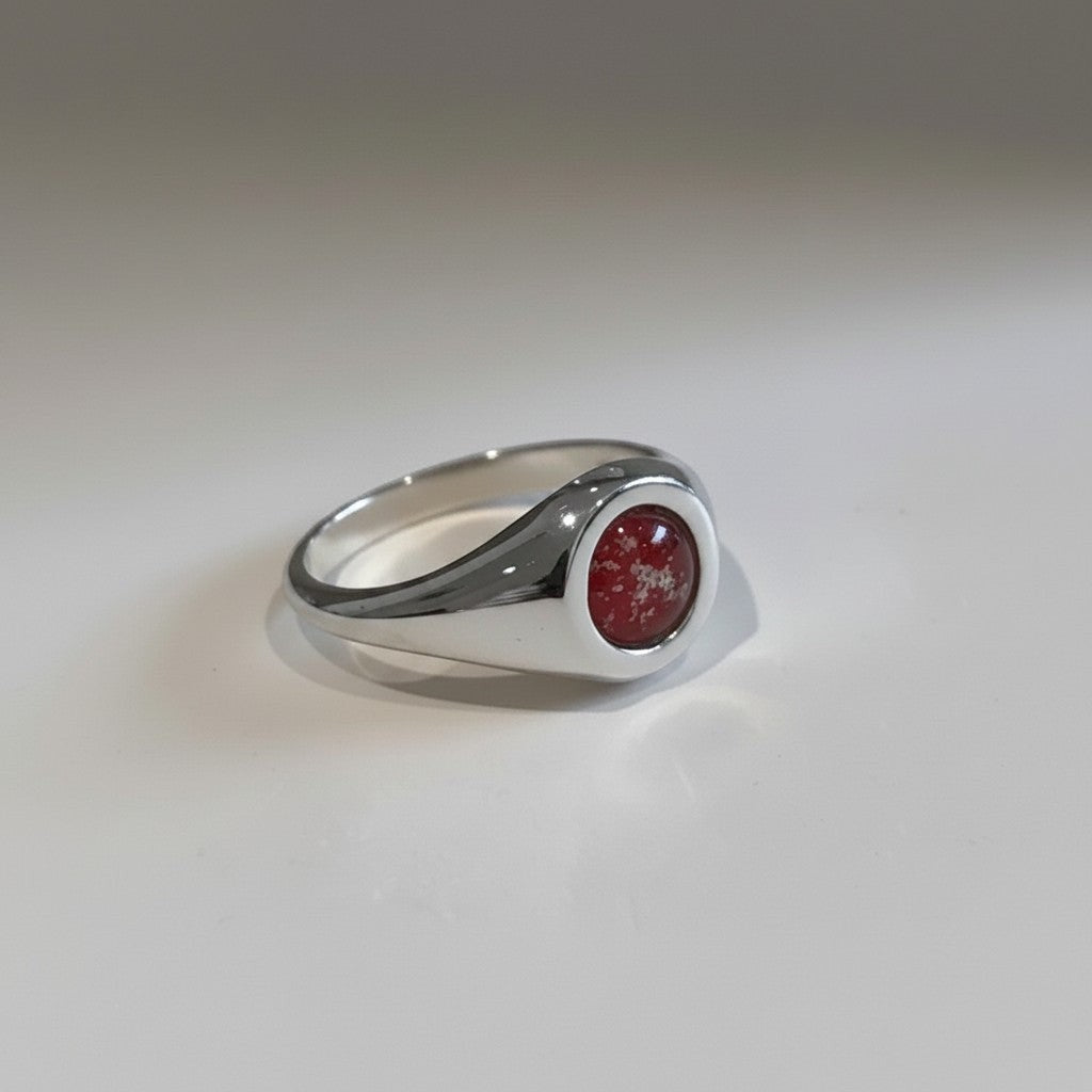 Ashes In Jewellery 14k yellow gold signet ring with red and white speckled cremation ash inlay. Round cabochon stone.