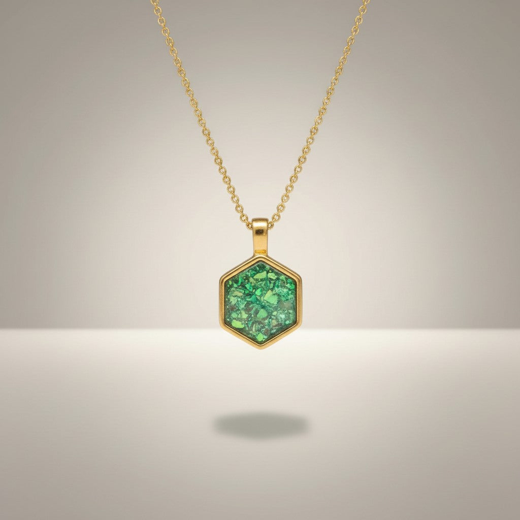 Ashes In Jewellery gold hexagon memorial pendant with green ashes inlay. Holds ashes.