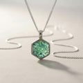 Ashes In Jewellery silver hexagon memorial pendant with green cremation ashes inside. A unique keepsake.
