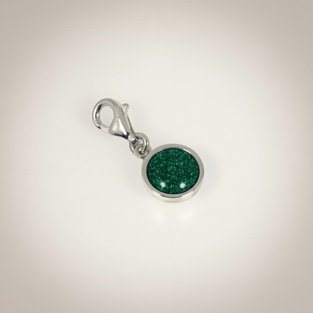 Ashes In Jewellery silver-tone round charm with red glitter cremation ash and lobster clasp.