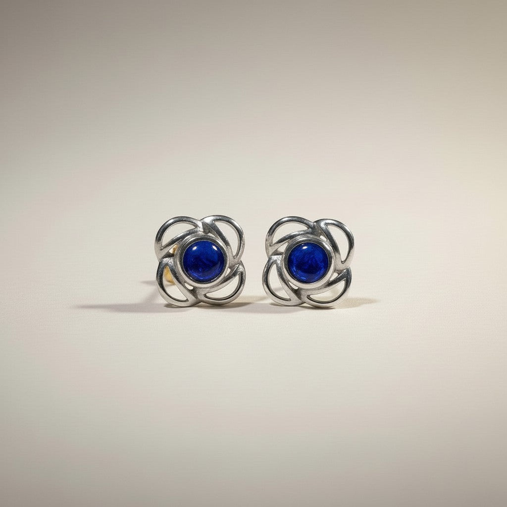 Ashes In Jewellery gold-tone stud earrings with deep red stone and swirling metalwork, screw-back closure.