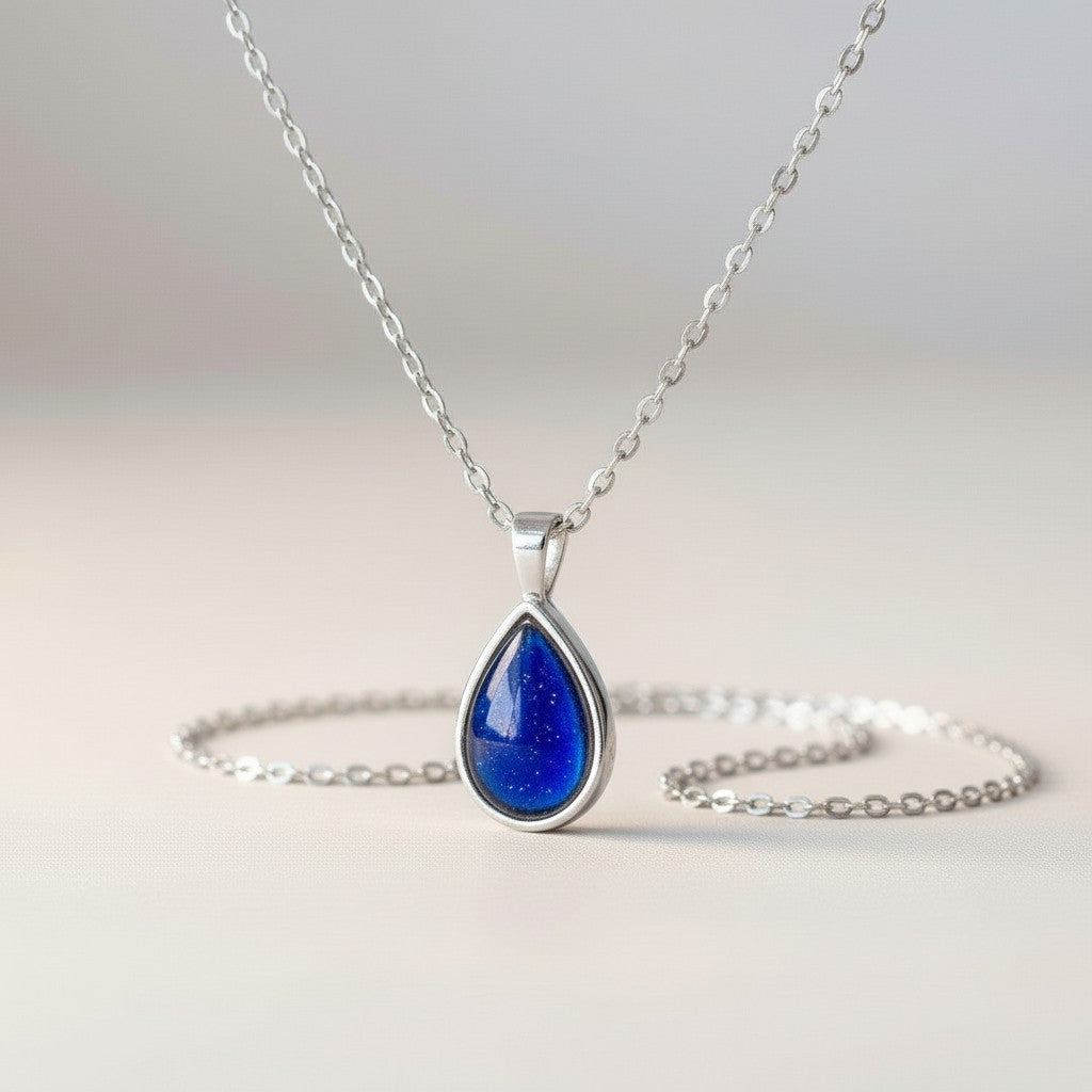 Ashes In Jewellery teardrop pendant necklace with a vibrant blue stone and gold-tone chain.