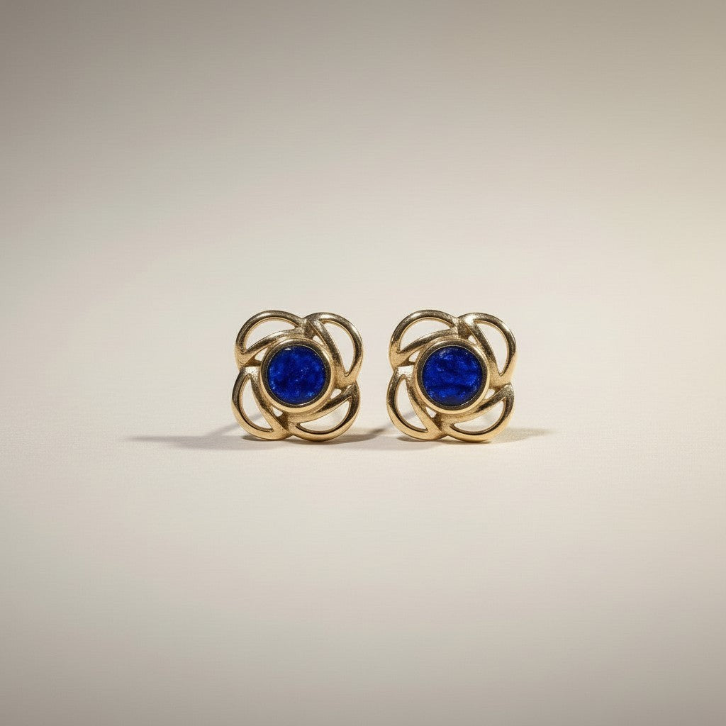 Ashes In Jewellery gold-tone stud earrings with deep red stone and swirling metalwork, screw-back closure.