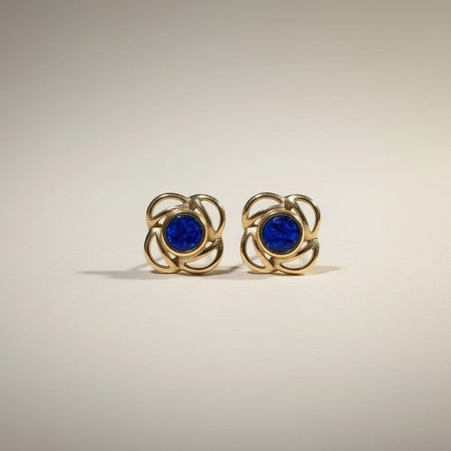 Ashes In Jewellery gold-tone stud earrings with deep red stone and swirling metalwork, screw-back closure.