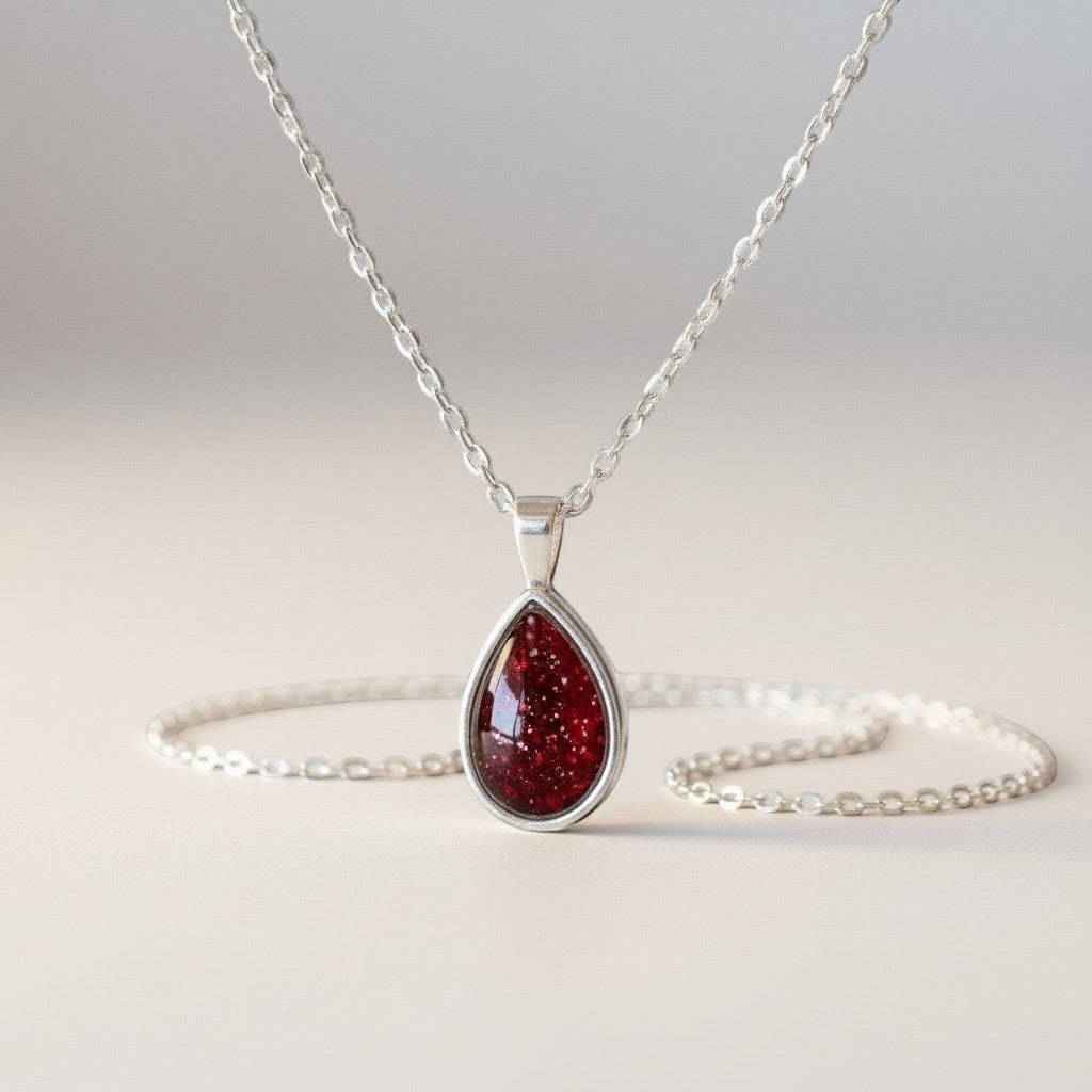 Ashes In Jewellery teardrop pendant necklace with green glitter stone in silver-tone bezel and delicate chain.
